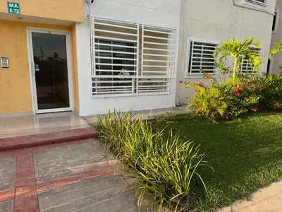 a house with a window with blinds on it at Casa las americas in La Cana