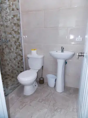 a bathroom with a toilet and a sink at Residencial Victoria in Sampiño