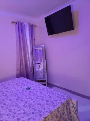 a purple room with a bed and a tv at comodidad y tranquilidad in Mendoza