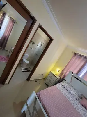 a bedroom with two mirrors and a bed with pink sheets at comodidad y tranquilidad in Mendoza