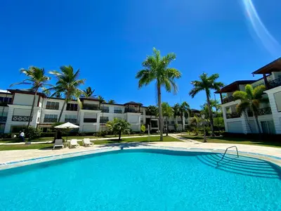 a swimming pool with palm trees and condos at Blue View Beachfront Apartment with Ocean View in Sampiño