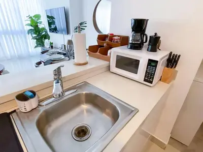 a kitchen counter with a sink and a microwave at Modern City Condo El Millon in El Jobo de Mendoza
