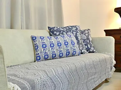 a couch with blue and white pillows on it at Vista Panorama Cipres in Hato Mayor