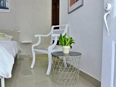 a white chair and a table in a bedroom at Villa Olga Studio in Rincón Largo