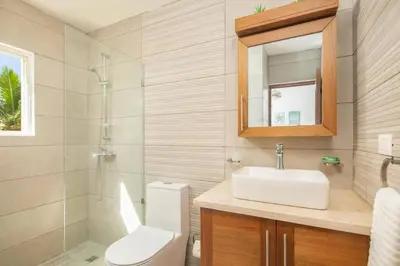 a bathroom with a sink and a toilet and a mirror at Direct View and Access to Beach! in Eslabón