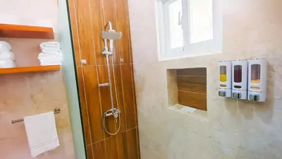 a bathroom with a shower and a door with a mirror at Brisa Atlántico - Secluded Beach in La Piña