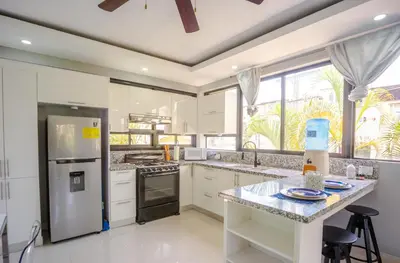 a kitchen with white appliances and a large window at Beautifully updated in the heart of town in Cabarete