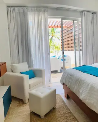 a bedroom with a bed and a couch and a chair at Luxury Penthouse Coson bay in Las Terrenas
