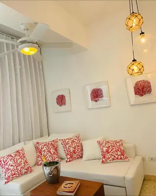 a living room with a white couch with red and white pillows at Luxury Penthouse Coson bay in Las Terrenas