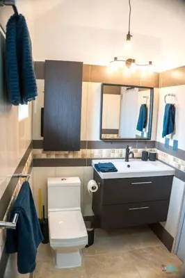 a bathroom with a white toilet and a sink at Ocean One Beach Condos Cabarete in Cabarete