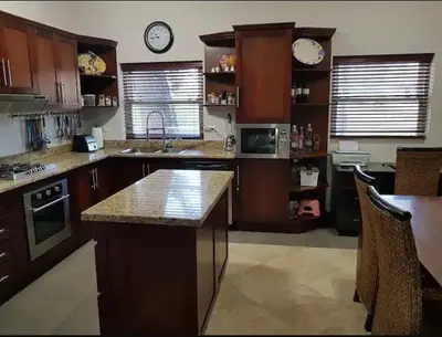 a kitchen with wooden cabinets and clocks on the wall at Ocean One Beach Condos Cabarete in Cabarete