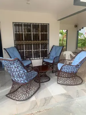 a group of chairs and a table on a porch at Romeos Place in Las Coles
