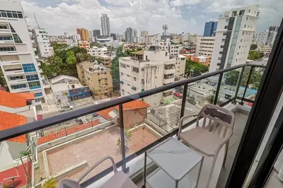 a balcony with two chairs and a view of a city at Cozy, Centric 1BR Condo, Pool in Los Prados