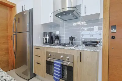 a kitchen with a refrigerator and a stove top oven at Cozy, Centric 1BR Condo, Pool in Los Prados