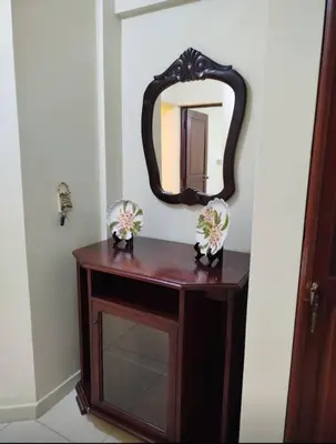 a wooden table with a mirror on a wall at Apartamento próximo al centro médico HOMS in Hato Mayor