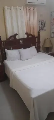 a bedroom with a large bed with white sheets and pillows at Villabenedetta santo domingo in Varía