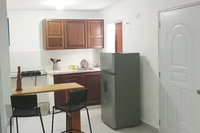 a kitchen with a refrigerator and a table and chairs at Aparta estudio 2 El Cacique, próximo malecón SD in Santo Domingo