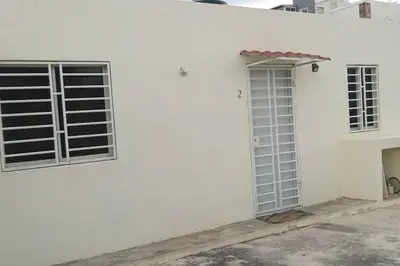 a white building with two windows and a door at Aparta estudio 2 El Cacique, próximo malecón SD in Santo Domingo