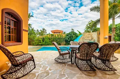 a patio with a table and chairs next to a pool at Cabarete Oceanview Villa Pool Oasis Beach Access in Cafemba