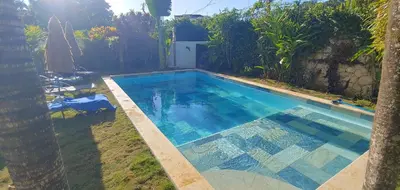 a swimming pool in the backyard of a house at Charmant appartement cuisine 1 chambre AC Bonita in El Hoyo del Cacao