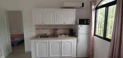 a kitchen with white cabinets and a white refrigerator at Charmant appartement cuisine 1 chambre AC Bonita in El Hoyo del Cacao