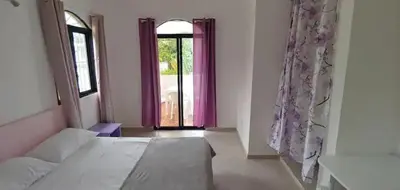 a bedroom with a large bed and a window at Charmant appartement cuisine 1 chambre AC Bonita in El Hoyo del Cacao