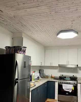 a kitchen with a stainless steel refrigerator and blue cabinets at Villa Carmen en Jarabacoa in La Represa