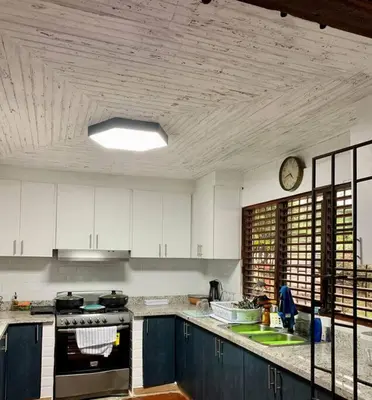 a kitchen with blue cabinets and a clock on the ceiling at Villa Carmen en Jarabacoa in La Represa