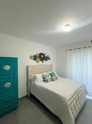 a bedroom with a bed and a blue cabinet at A private cozy-beach apartment in Dominicus in La Laguna