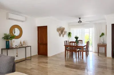 a dining room and living room with a table and chairs at Apartamento en Punta Cana, White sands in Punta Cana