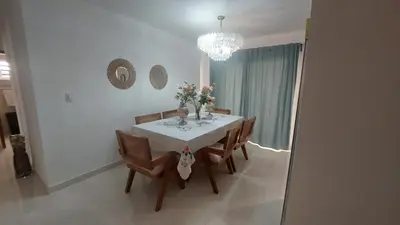 a dining room with a table and chairs and a chandelier at Apartamento Residencial sembrador 3 ciudad Juan Bosch in La Javilla