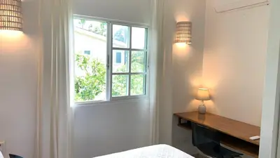 a bedroom with a window and a bed and a desk at Beachfront Unit with Stunning Sunsets and Starlink Internet ! in Las Terrenas