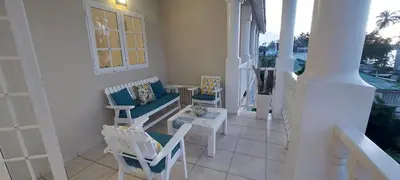 a porch with chairs and a couch and a table at Beachfront Unit with Stunning Sunsets and Starlink Internet ! in Las Terrenas