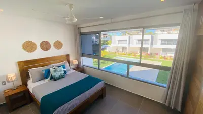a bedroom with a bed and a large window at Modern Zen Villa Next to Playa Popy in Las Terrenas