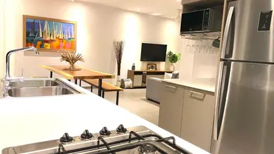 a kitchen with a stainless steel refrigerator and a table at Modern Zen Villa Next to Playa Popy in Las Terrenas