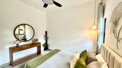 a bedroom with a bed and a mirror at All-New Zen Apartment with TreeTops and Ocean Views ! in Las Terrenas