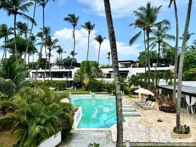 an aerial view of a resort pool with palm trees at Beachfront complex 3BD 3BA with pool in Las Terrenas