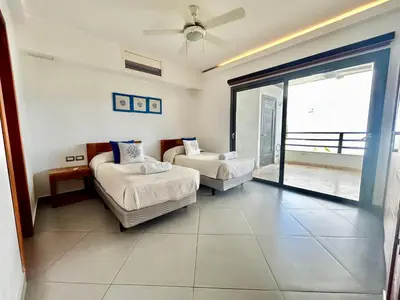a bedroom with two beds and a sliding glass door at Beachfront complex 3BD 3BA with pool in Las Terrenas