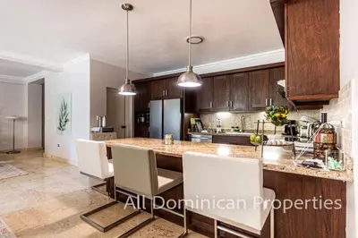 a kitchen with a large island with white chairs at Hispaniola Beach Official, Sosua! in Sosúa