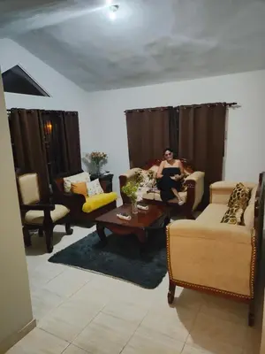 a woman sitting on a couch in a living room at My home in San Felipe de Puerto Plata