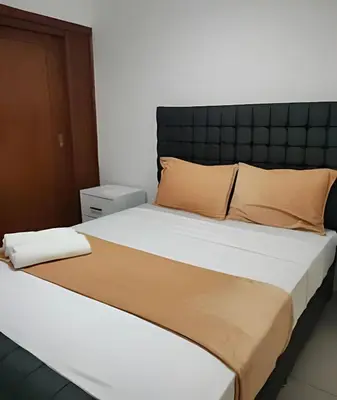 a bedroom with a large bed with orange pillows at Stylish 3BR,2BA in Santo Domingo Este in Mendoza