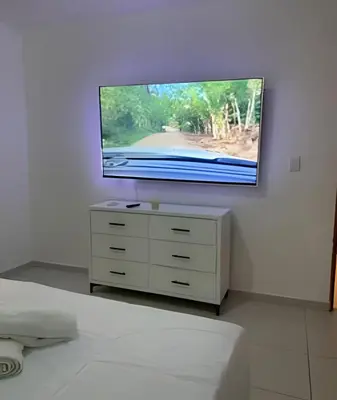 a flat screen tv on a wall in a bedroom at Stylish 3BR,2BA in Santo Domingo Este in Mendoza