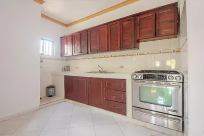 a kitchen with wooden cabinets and a stainless steel oven at Eden House in Río San Juan