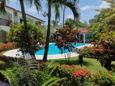 a view of a resort with a swimming pool and flowers at Apartamentos confortables in La Barbacoa