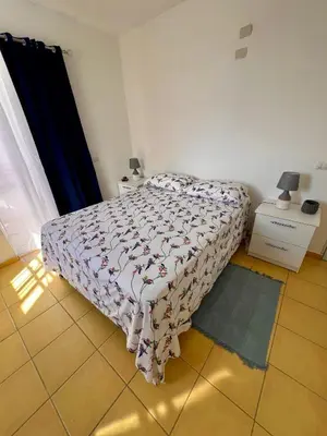 a bedroom with a bed with a comforter on it at Apartamento Aurora in Bayahibe