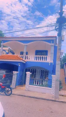 a blue and white house with a motorcycle parked in front at Casita Azul in Isabel de Torres