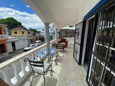 a balcony with a glass table and chairs on a balcony at Casita Azul in Isabel de Torres