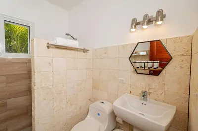 a bathroom with a sink and a toilet and a mirror at Coastal Luxury 2-Bed w Pool Access in Paraiso Bayahibe in Bayahibe