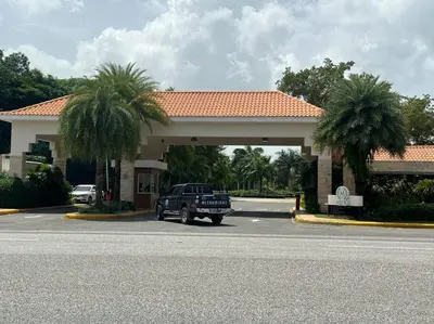 a truck parked in front of a hotel with palm trees at Hermosa villa en metro country club Juan dolio in Paraíso
