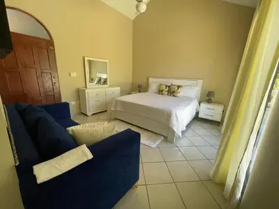 a bedroom with a bed and a blue couch at Villa Michel in Laguna del Higüero